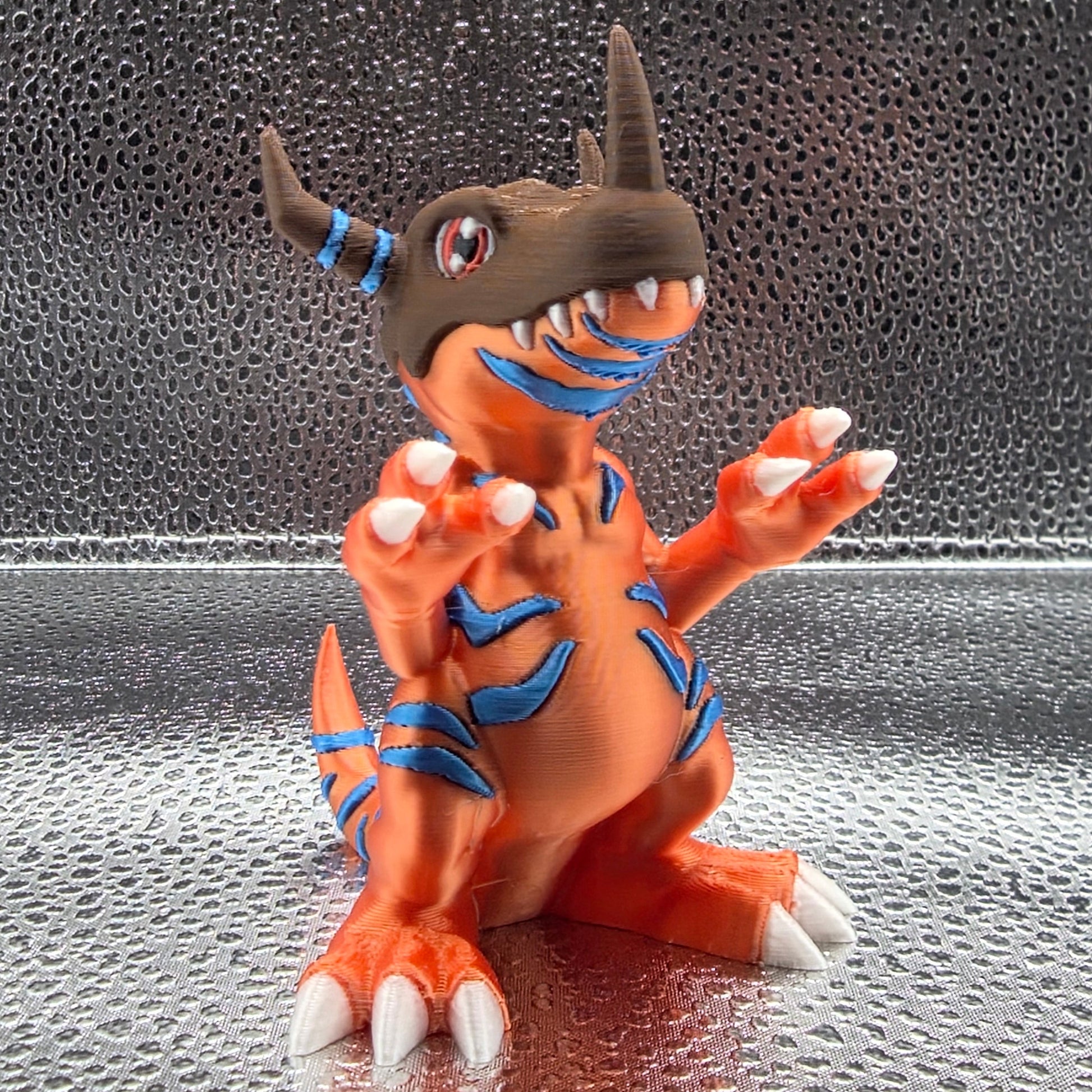 Orange and brown toy figure with blue accents on a reflective surface