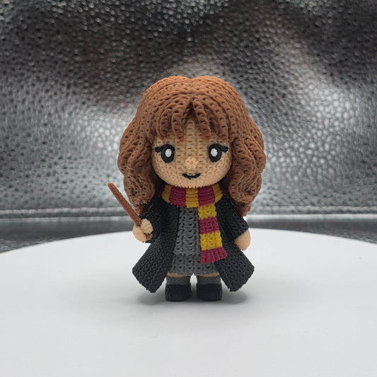 Small plush toy of a character with a scarf on a textured surface