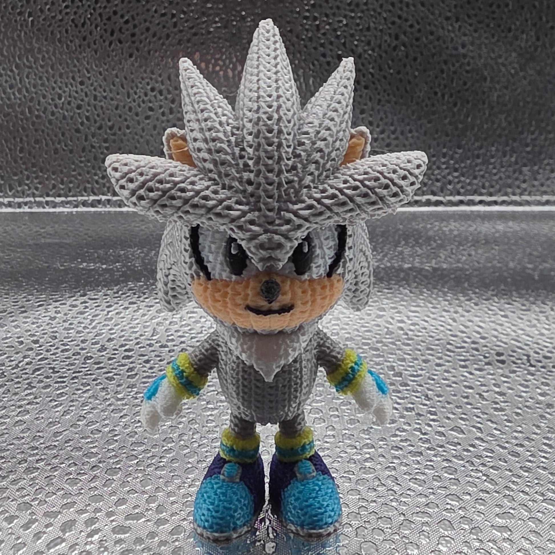 Crocheted character on a textured glass surface