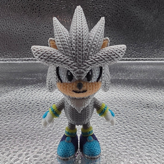 Crocheted character on a textured glass surface